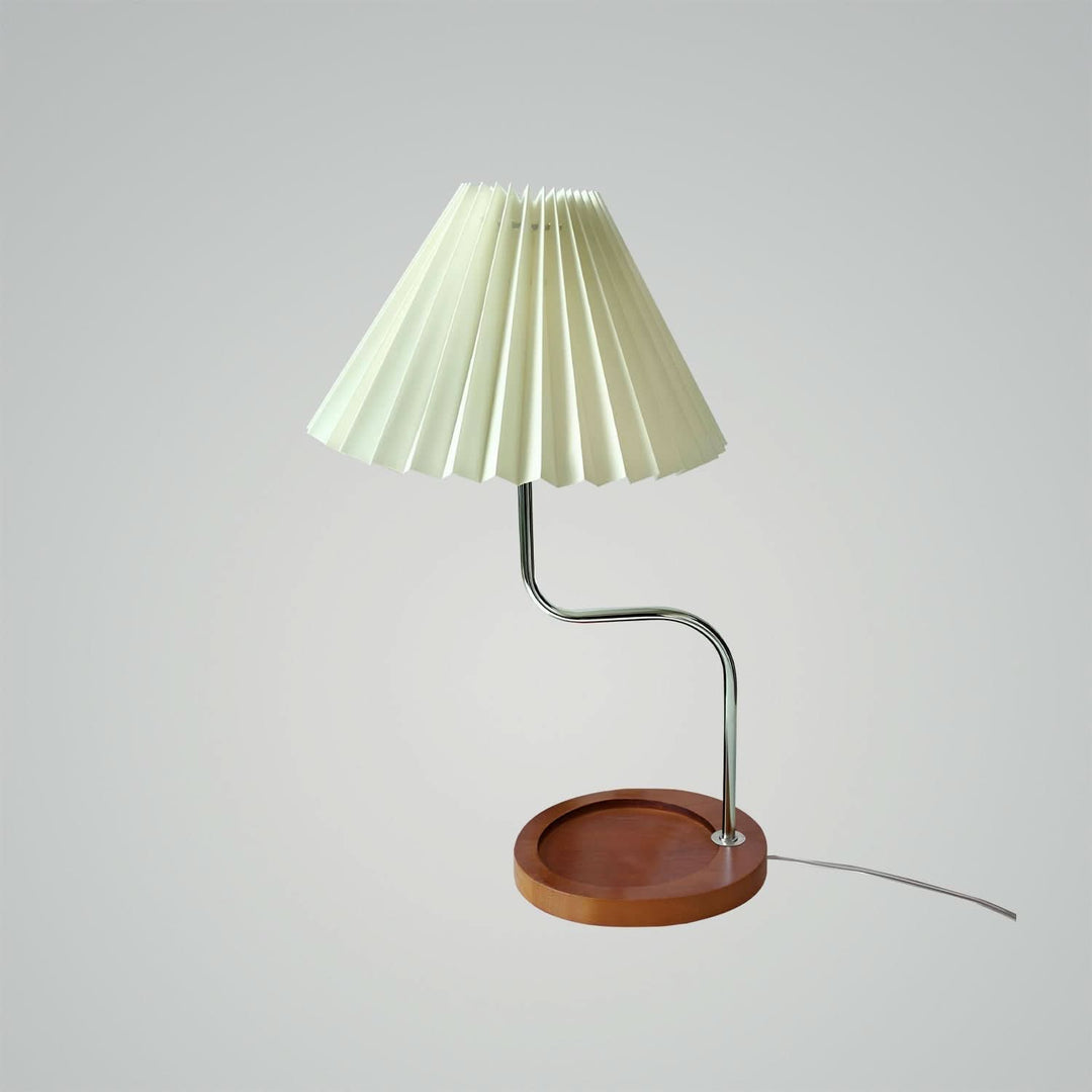 Dark blue pleated lamp casting warm glow in cozy bedroom
